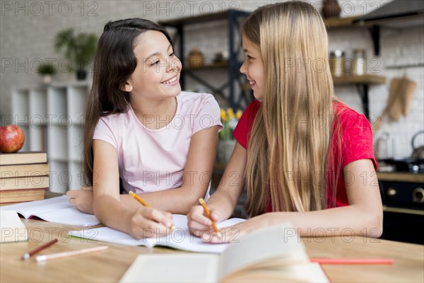 Schoolgirls doing homework looking each other