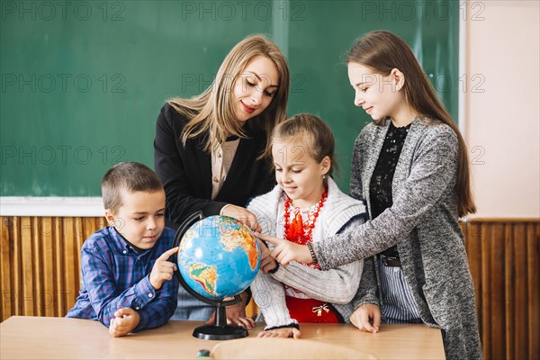 School teacher students working with globe