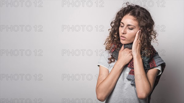 Sick woman with woolen scarf around her neck suffering from flu