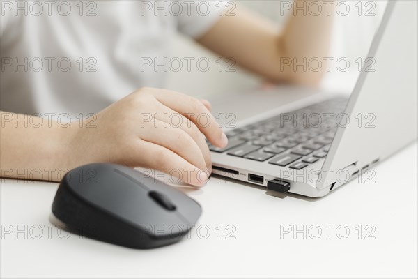 Side view child using laptop mouse