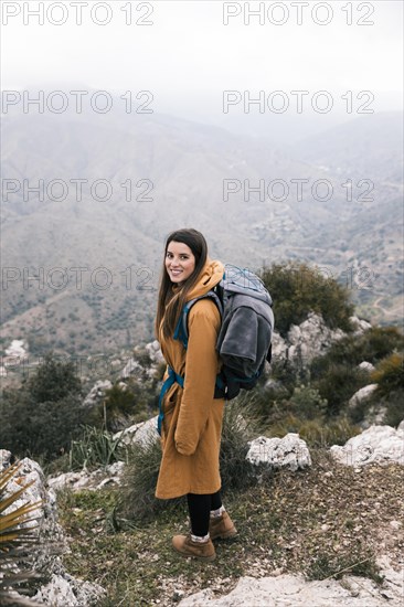 Side view female hiker with her backpack hiking mountains