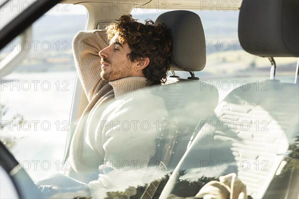 Side view man relaxing car while road trip