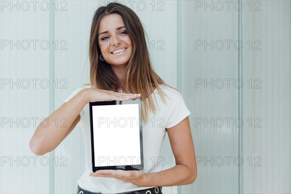 Smiley young girl holding tablet