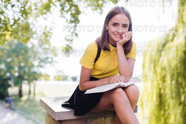 Smiling girl with book park