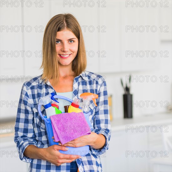 Smiling housewife holding cleaning equipment hands