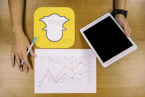 Social media planner analyzing snapchat graph with digital tablet