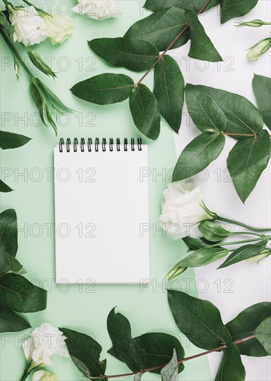 Spiral notepad eustoma flowers leaves dual green white background