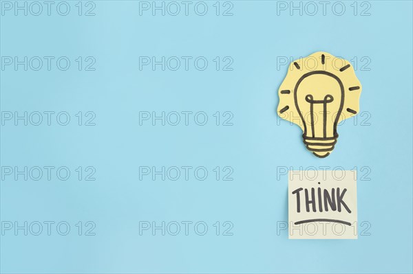 Think sticky note hand drawn yellow light bulb blue background