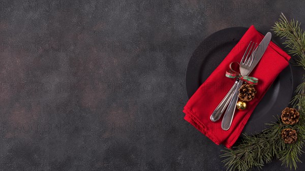 Top view christmas table arrangement with pine cones cutlery