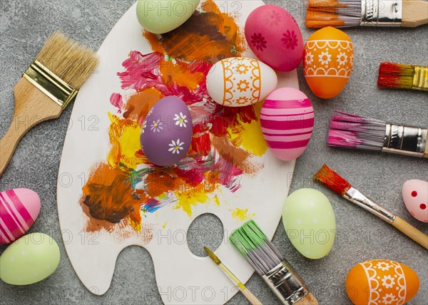 Top view colorful easter eggs with paint brushes palette