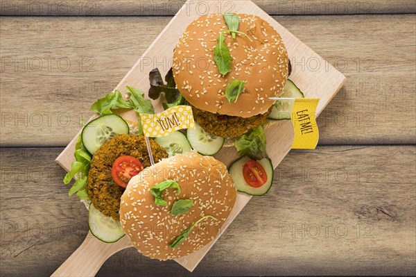 Top view delicious vegan burgers wooden board