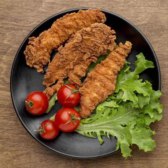 Top view fried chicken with tomatoes salad plate