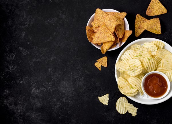 Top view potato chips nacho chips with ketchup