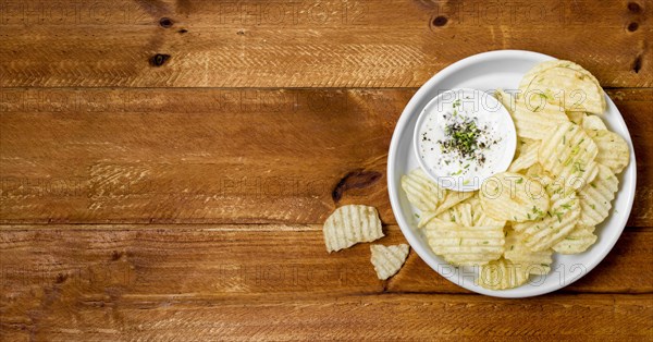 Top view potato chips plate with sauce copy space