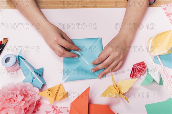 Top view woman hand making origami craft table