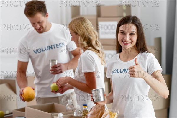 Volunteers helping with food donations giving thumbs up