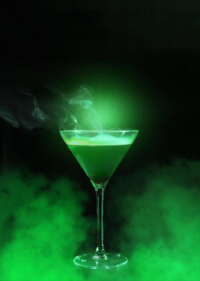 Wineglass with liquor green smoke