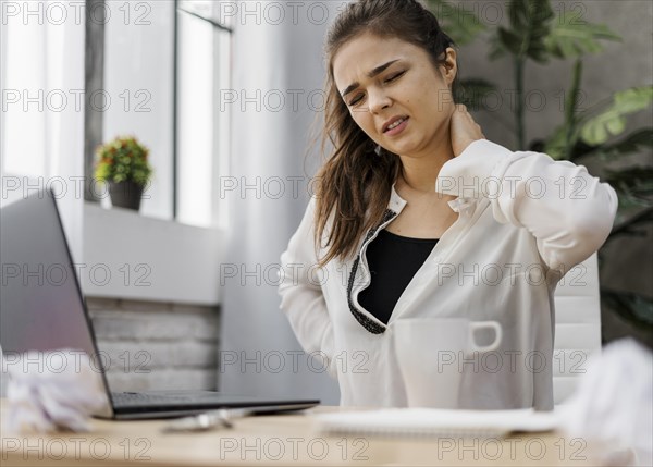 Woman having neckache while working home