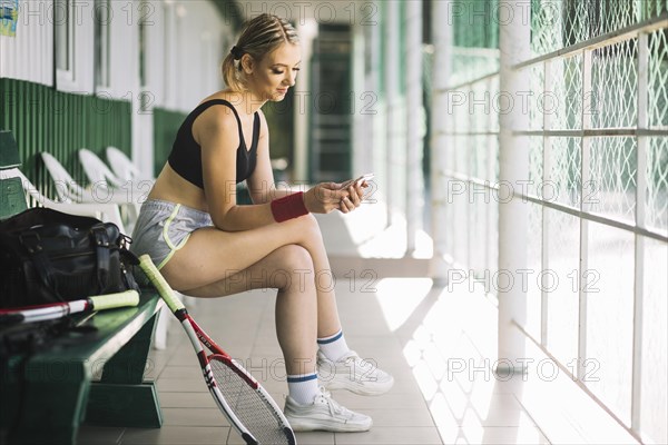 Woman tennis player checking her phone