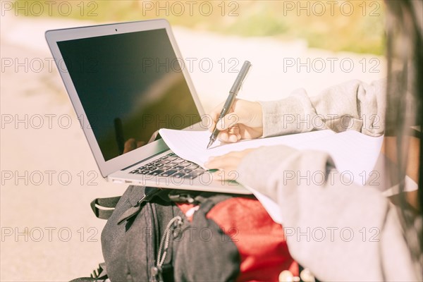 Woman writing by hand notebook sunny day