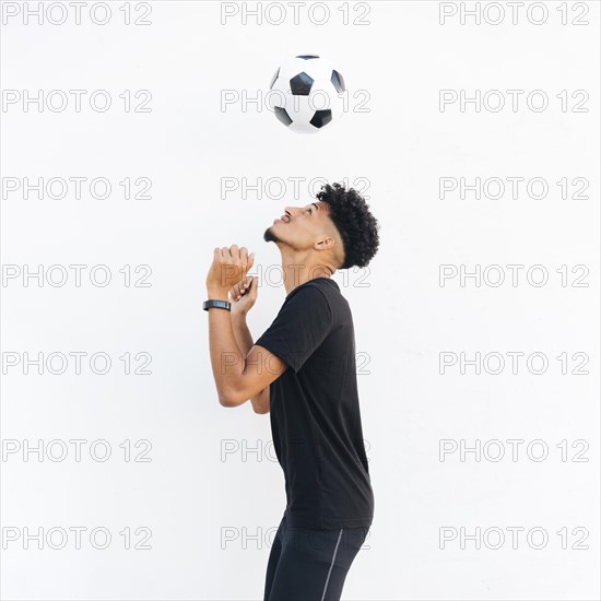Young black man juggling soccer ball