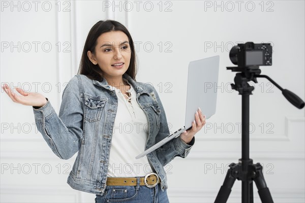 Young blogger holding laptop
