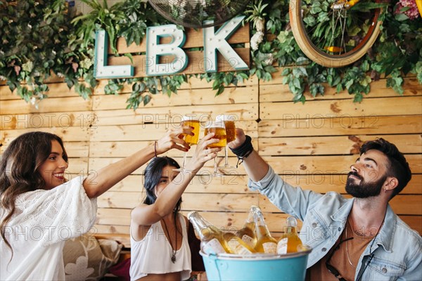 Young friends toasting with beer