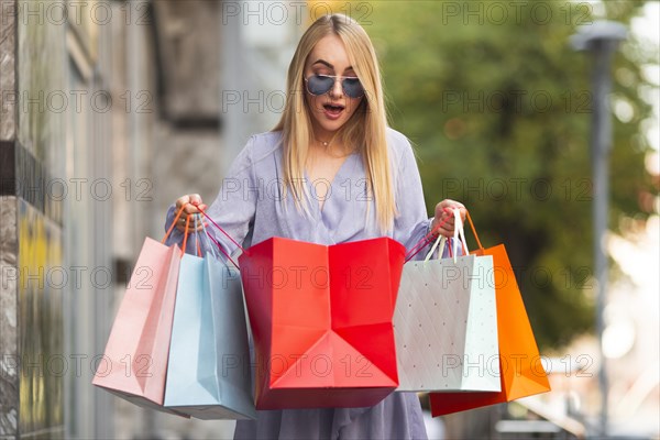 Young woman surprised by shoppings bags