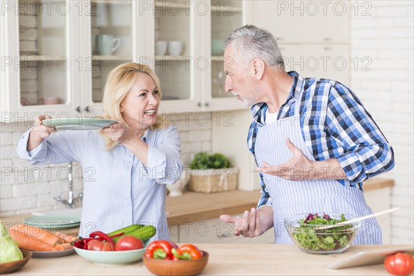 Angry senior couple fighting with each other kitchen