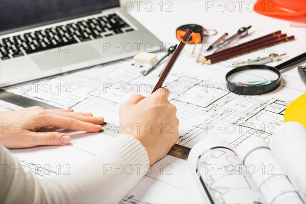 Architect drawing blueprint with pencil