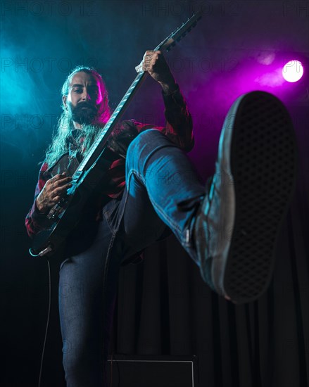 Artist playing guitar low view