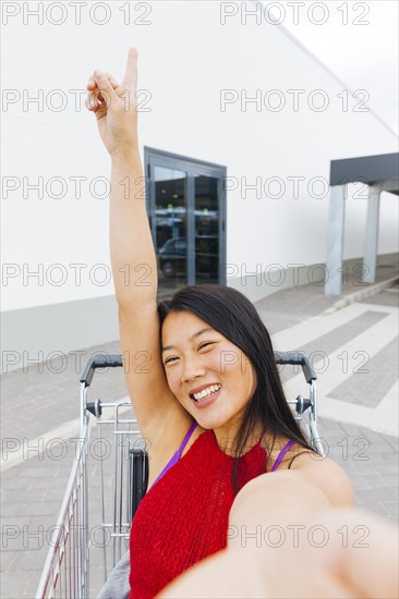 Asian woman posing taking selfie shopping trolley