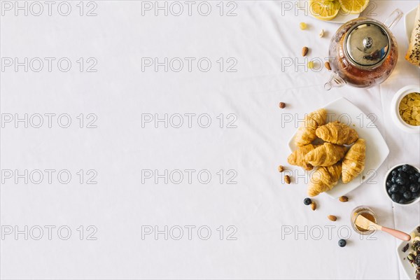 Baked croissant fruits tea dryfruits white background