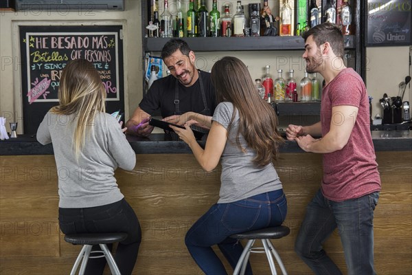 Barman showing menu customers bar