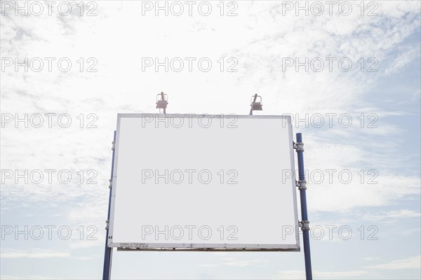 Big empty billboard with two lamp against sky