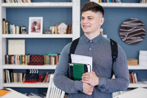 Cheerful student with textbook notebook