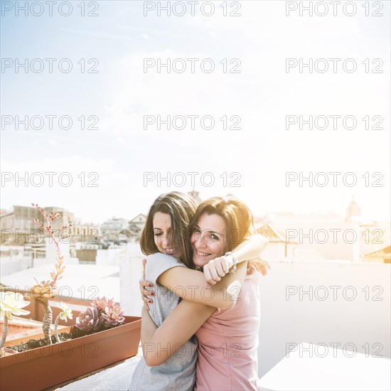 Cheerful women hugging street