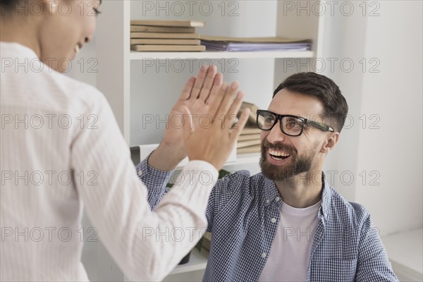 Close up businessman giving high five woman