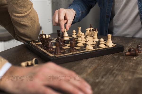 Close up father son playing chess