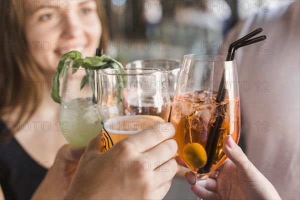 Close up friends toasting glasses cocktail