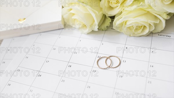 Close up gift box roses wedding rings calendar