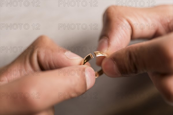 Close up hands holding broken ring