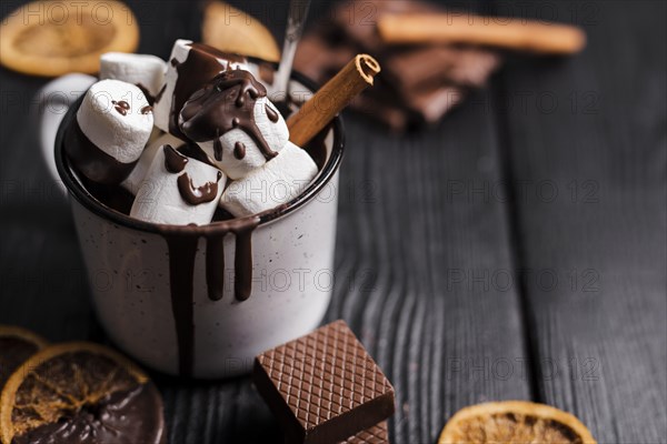 Close up hot chocolate with marshmallows cinnamon stick dried orange slices