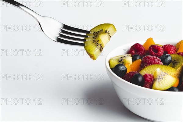Close up kiwi fork with bowl fruit