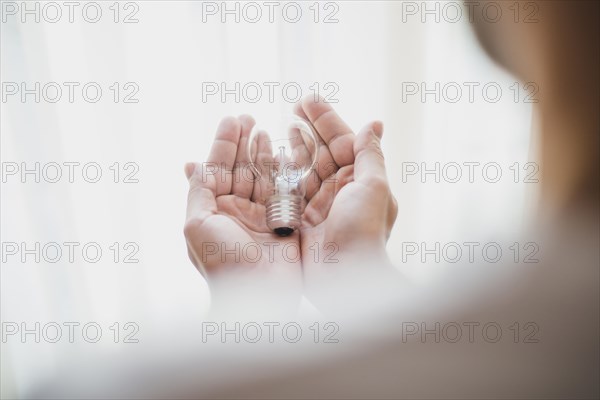 Close up man s hand holding light bulb