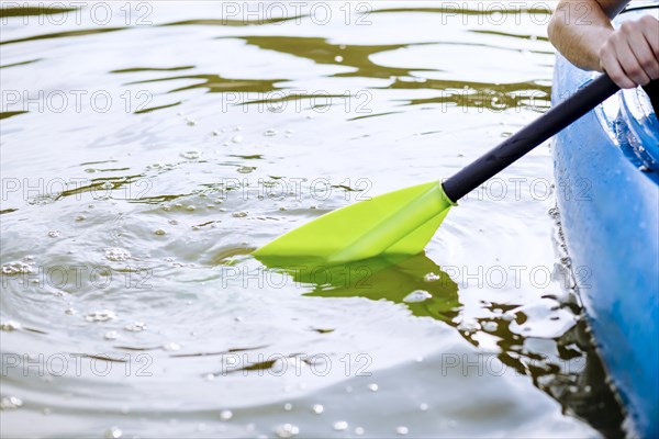 Close up person s hand paddling kayak