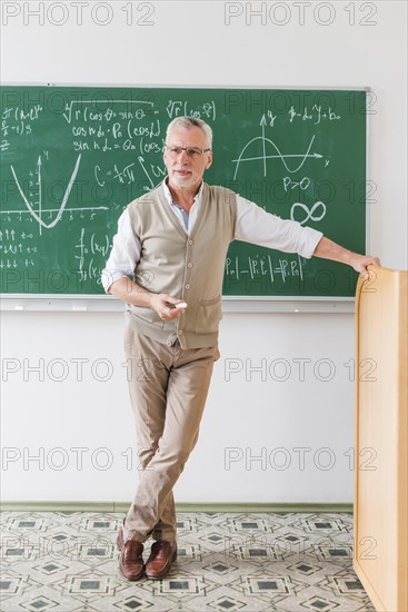 Confident aged math teacher looking class