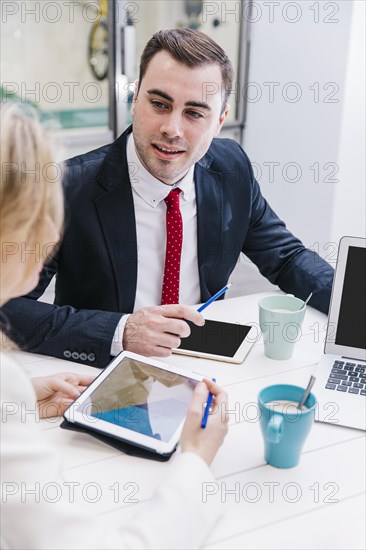 Content man chatting with colleagues table