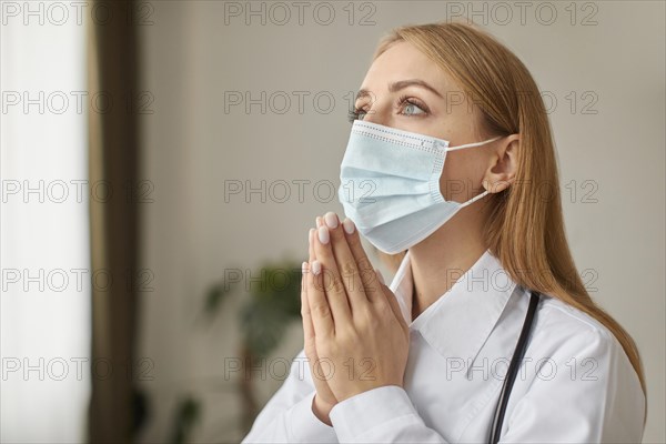 Covid recovery center female doctor with stethoscope medical mask praying