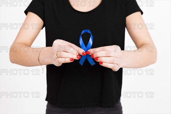 Crop woman showing blue ribbon